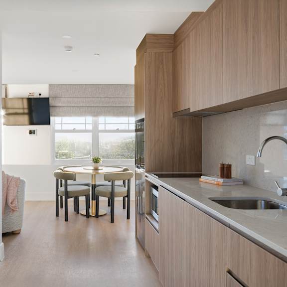 a modern kitchen with wooden cabinets and a dining table with chairs.