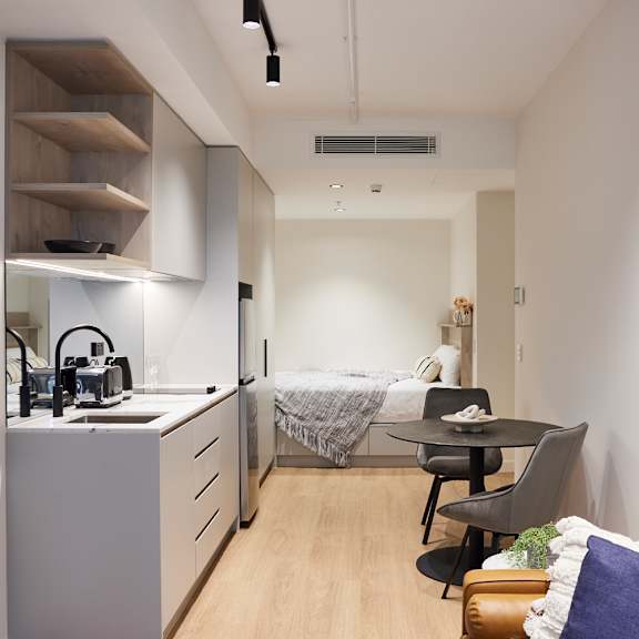 a small apartment with a kitchen and a bed