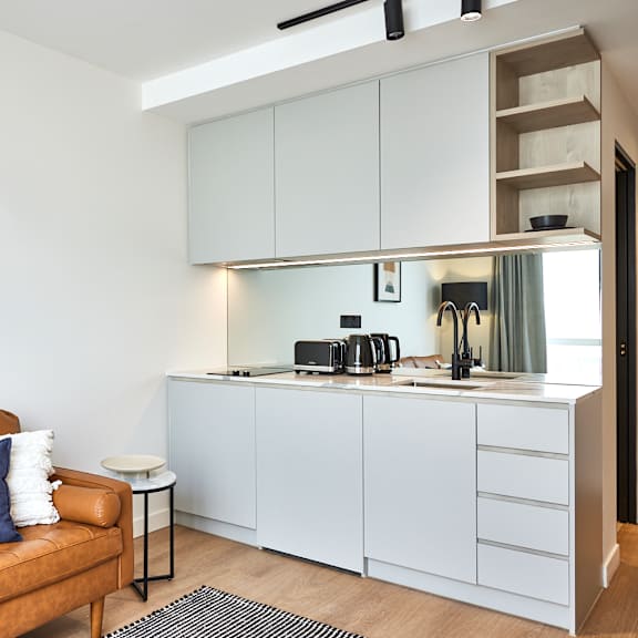 a living room with a couch and a kitchen in the background