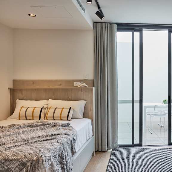 a bedroom with a bed and sliding glass doors