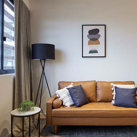 a couch with pillows in a room with a bed