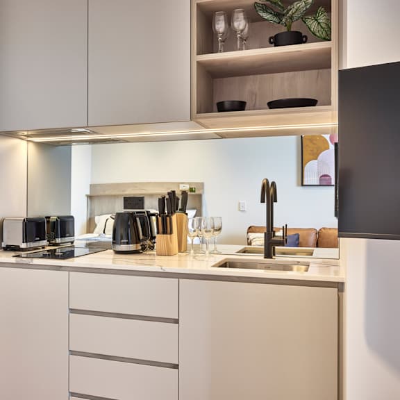 a kitchen with white cabinets and a stainless steel refrigerator and sink