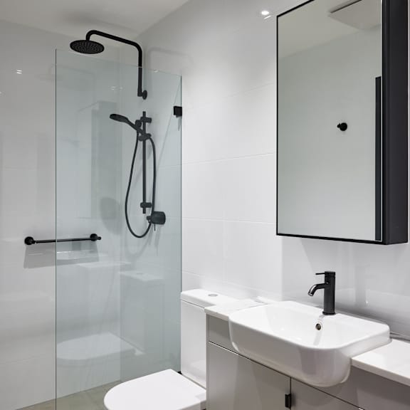 a white bathroom with a shower sink and toilet