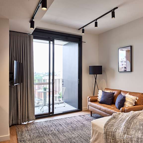 a living room with a couch and a door to a balcony