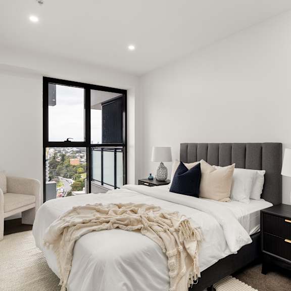 a bedroom with a large bed and a chair.