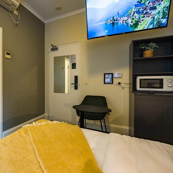 a bedroom with a bed and a tv in a room with a bathroom