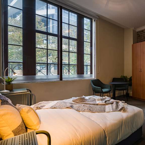 a bedroom with a bed and a couch and a window