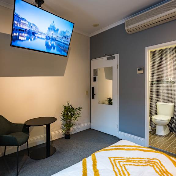 a hotel room with a bed and a tv on the wall