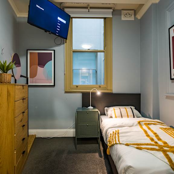 a bedroom with a bed and a dresser and a television
