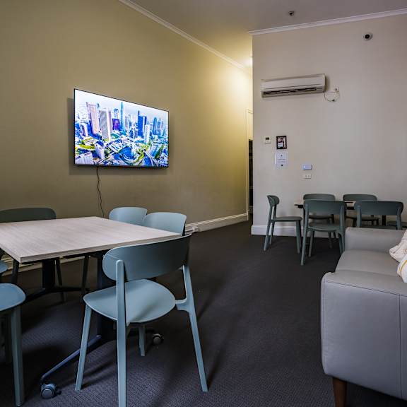 a seating area with a table and chairs and a tv