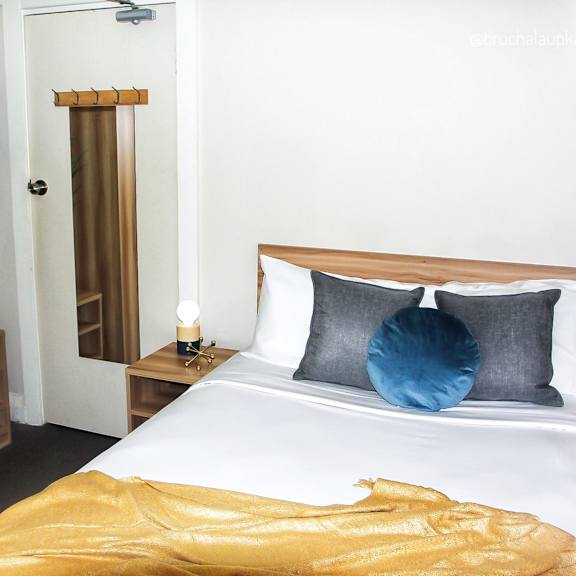 a bedroom with a white bed and a blue pillow