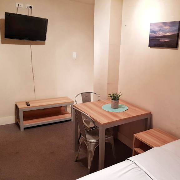 a small room with a bed and a desk and a television