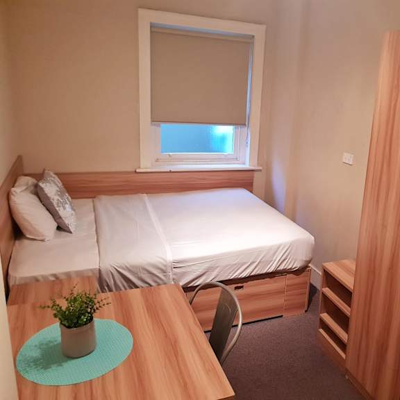 a small bedroom with a bed and a desk