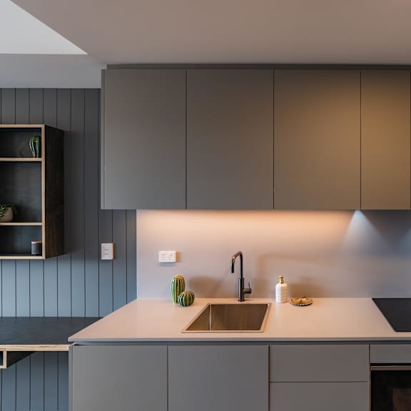 a kitchen with white counter top and stainless steel appliances