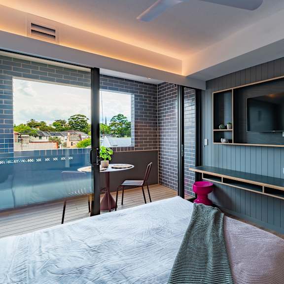 a hotel room with a bed and a tv on the wall