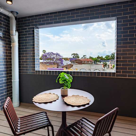 a patio with a table and chairs in front of a window