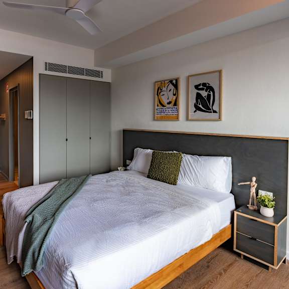 a bedroom with a large bed and a kitchen
