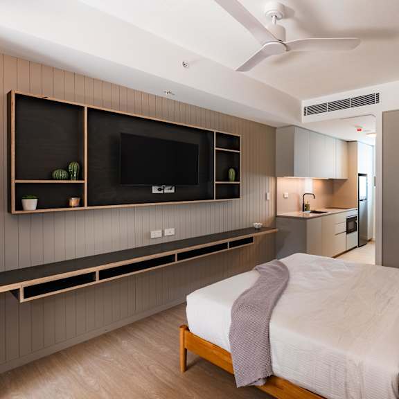 a bedroom with a bed and a tv on the wall