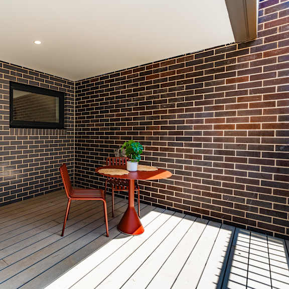 a room with a table and a chair in a brick wall