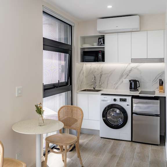 a living room with a table and chairs and a washing machine