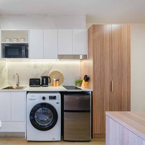 a kitchen and dining area with a washing machine and a dishwasher