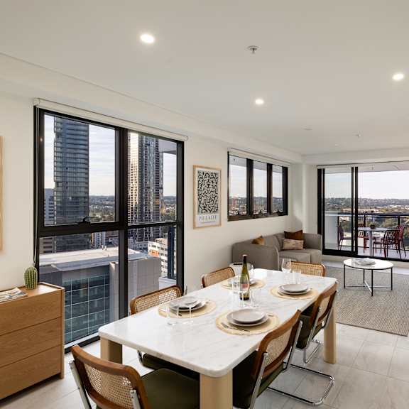 a dining room with a table set for two and a view of the city.