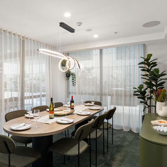 a dining room with a table set for two with a bottle of wine and a plate of food.