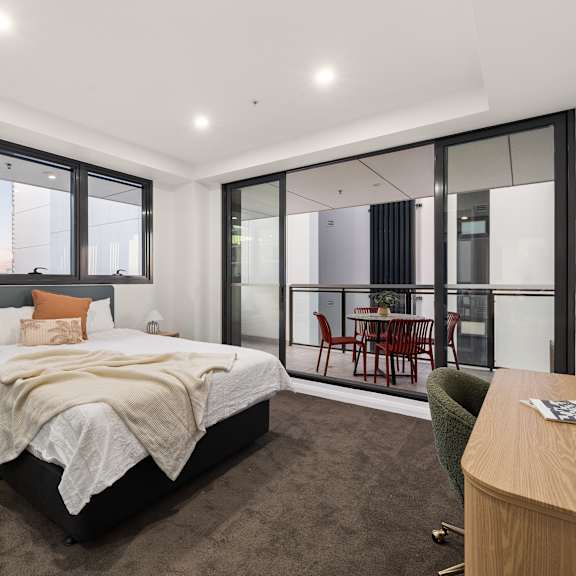 a bedroom with a large bed and a chair.