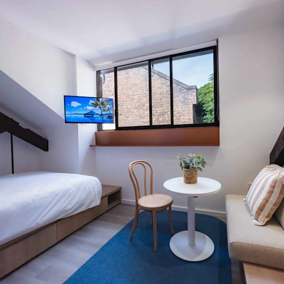 a room with a bed and a table and a window
