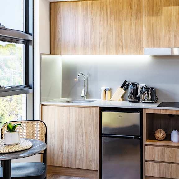 a small kitchen with a small table and a refrigerator and a sink