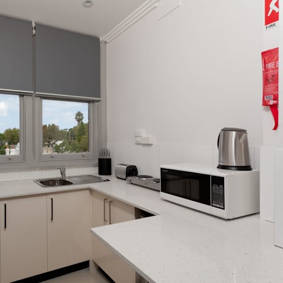 a kitchen with a sink and a microwave and a window