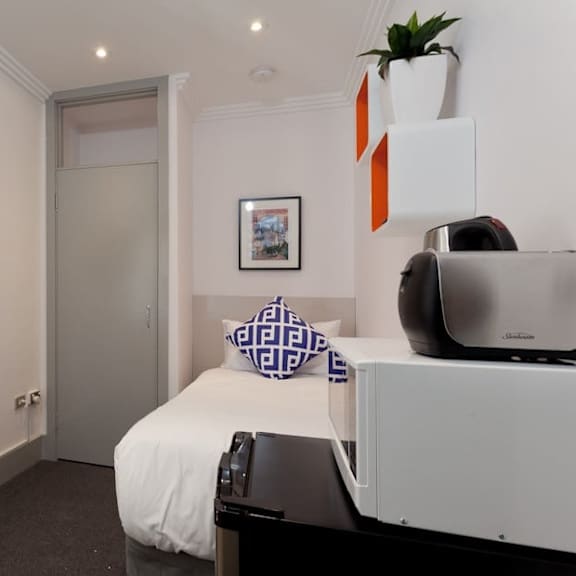 a small bedroom with a bed and a tv