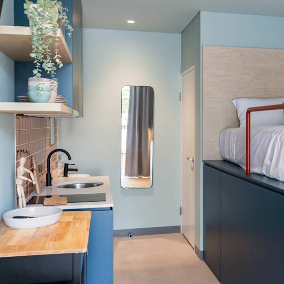 a bunk bed in a room with a kitchen and a sink