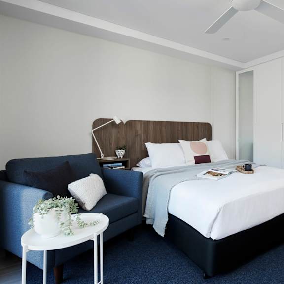 a bedroom with a bed and a couch in a hotel room