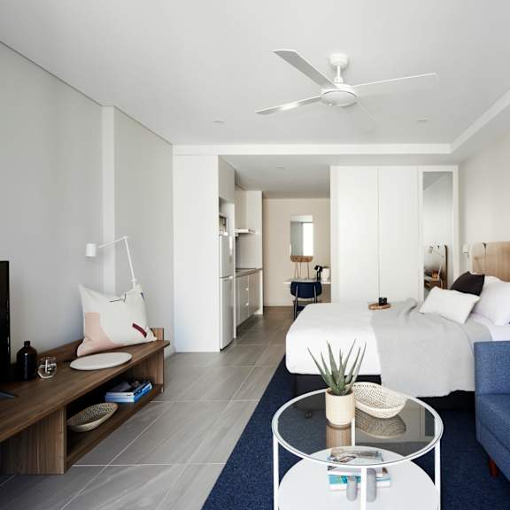 a bedroom with white walls and a blue couch