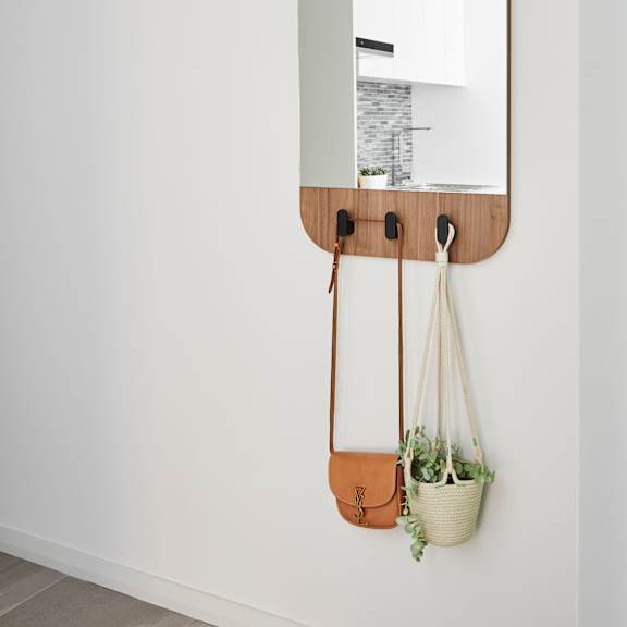 a mirror hanging on a wall with two hanging bags
