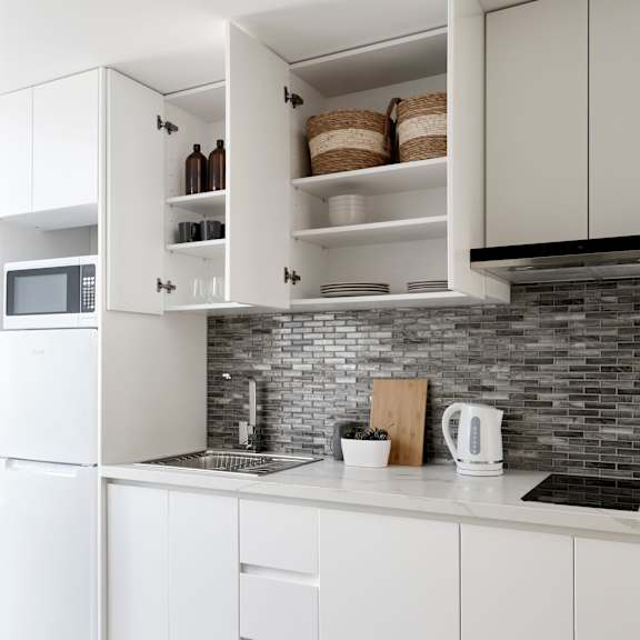 a white kitchen with white cabinets and a counter top