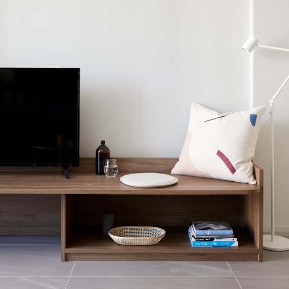 a bench with a pillow and a tv on it