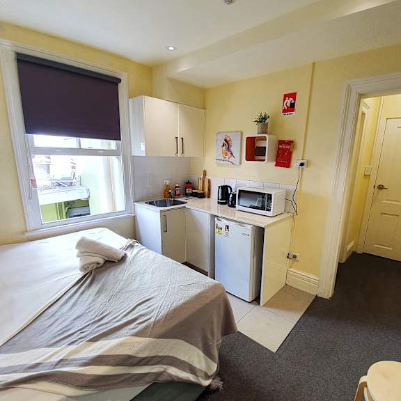 a small room with a bed and a kitchen