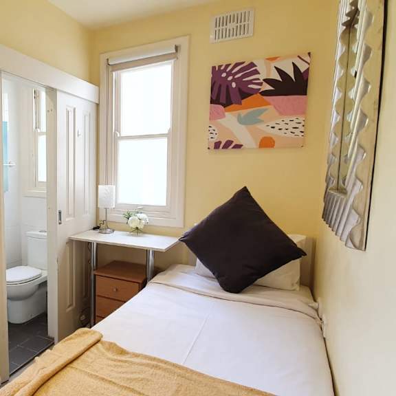 a bedroom with a bed and a bathroom with a sink and a toilet