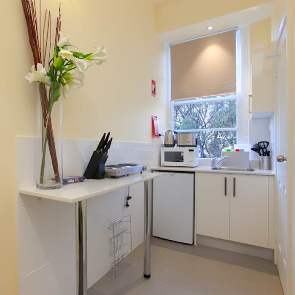 a kitchen with white cabinets and a sink and a window