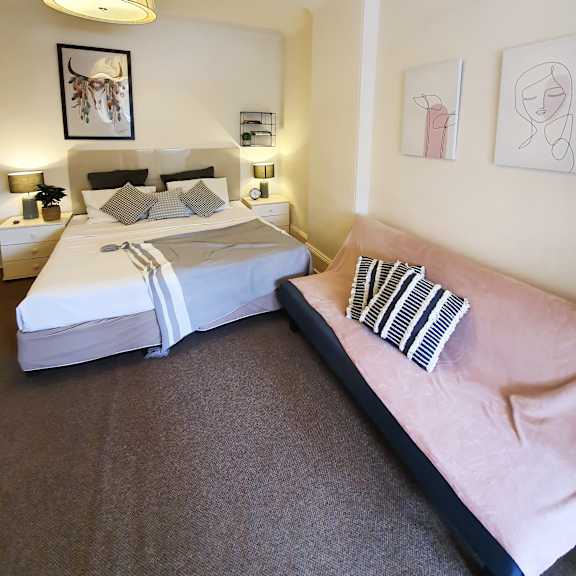 a bedroom with a bed and a couch and a lamp