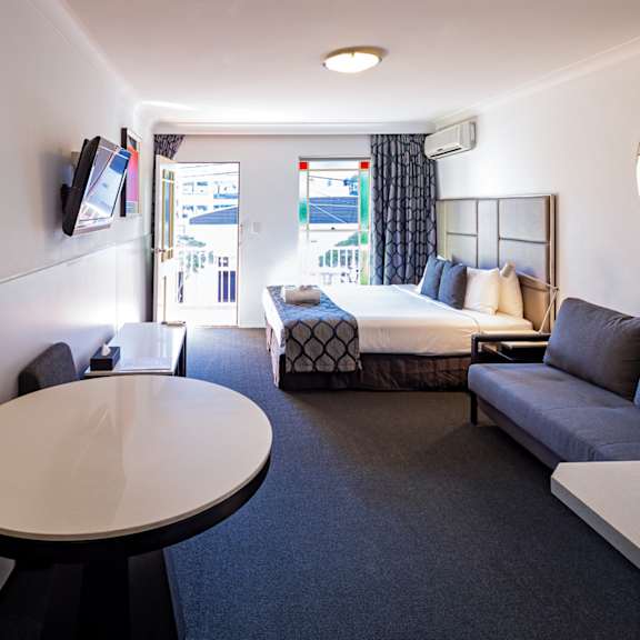 a hotel room with a bed and a couch and a table