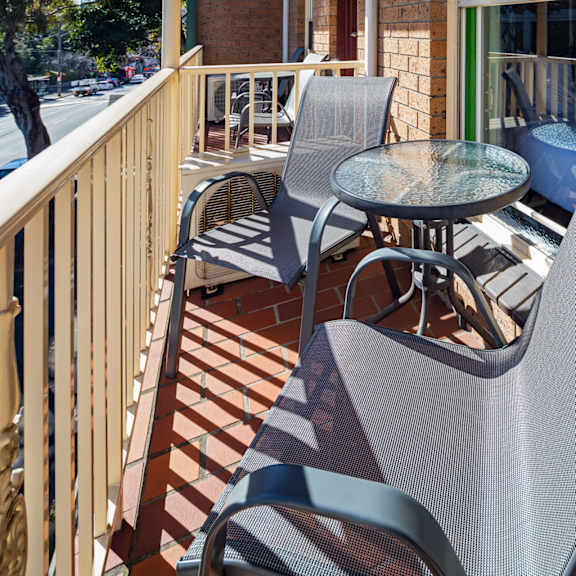 a patio with chairs and a table on a balcony