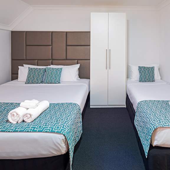 two beds in a hotel room with towels on them
