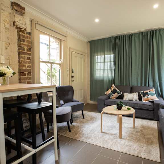 a living room with green curtains and a table and a couch