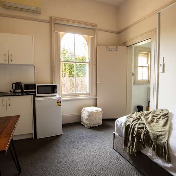 a small room with a bed and a kitchen