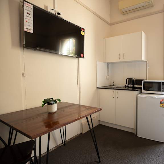 a small kitchen with a table and a refrigerator