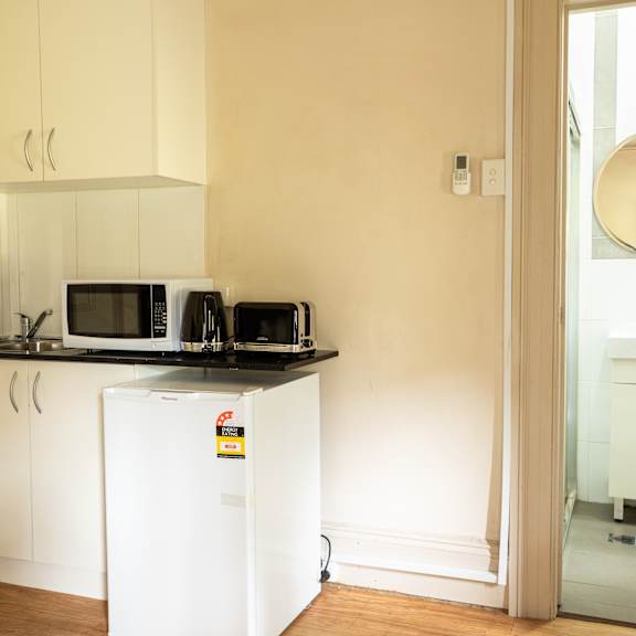 a small kitchen with a microwave and a refrigerator