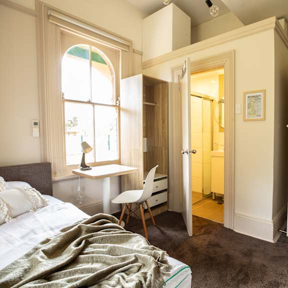 a bedroom with a bed and a desk and a bathroom
